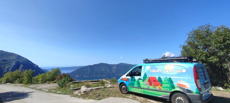 Van devant un paysage de montagne ensoleillée au Monténégro pendant un roadtrip