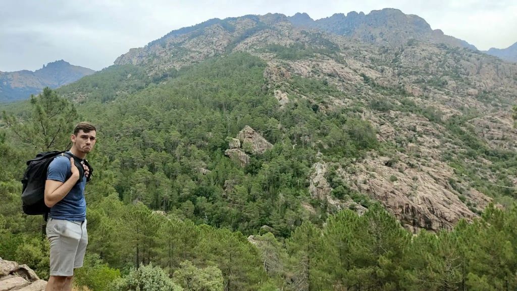 Homme seul en randonnée dans la forêt de Bonifatu, sur les sentiers corses, entouré de nature et de montagnes.